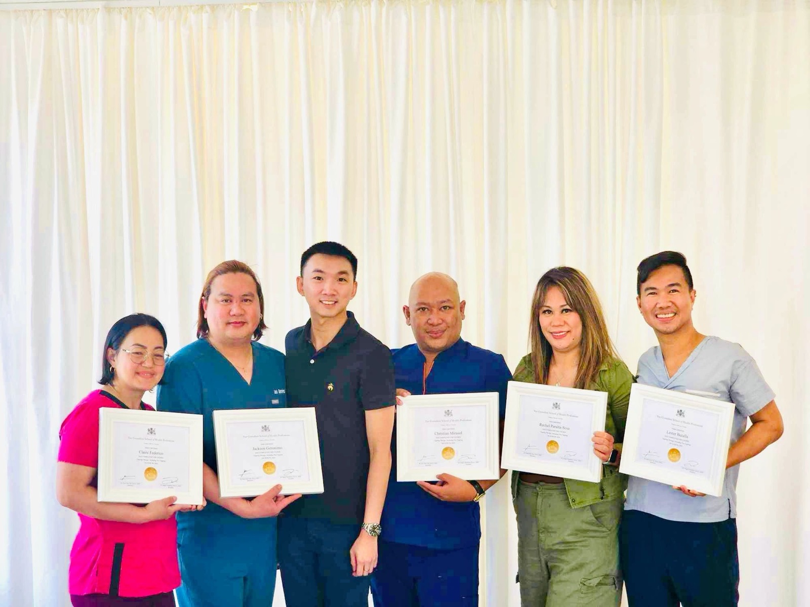 Graduates holding their certificates